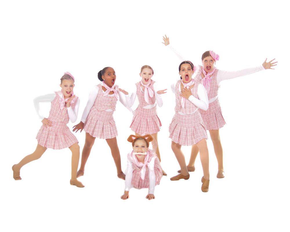 Young dancers in pink dresses perform playful choreographed movements.