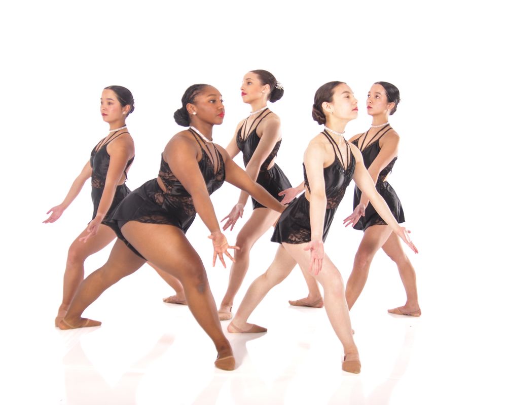 Modern dance ensemble in black performs dynamic contemporary choreography.