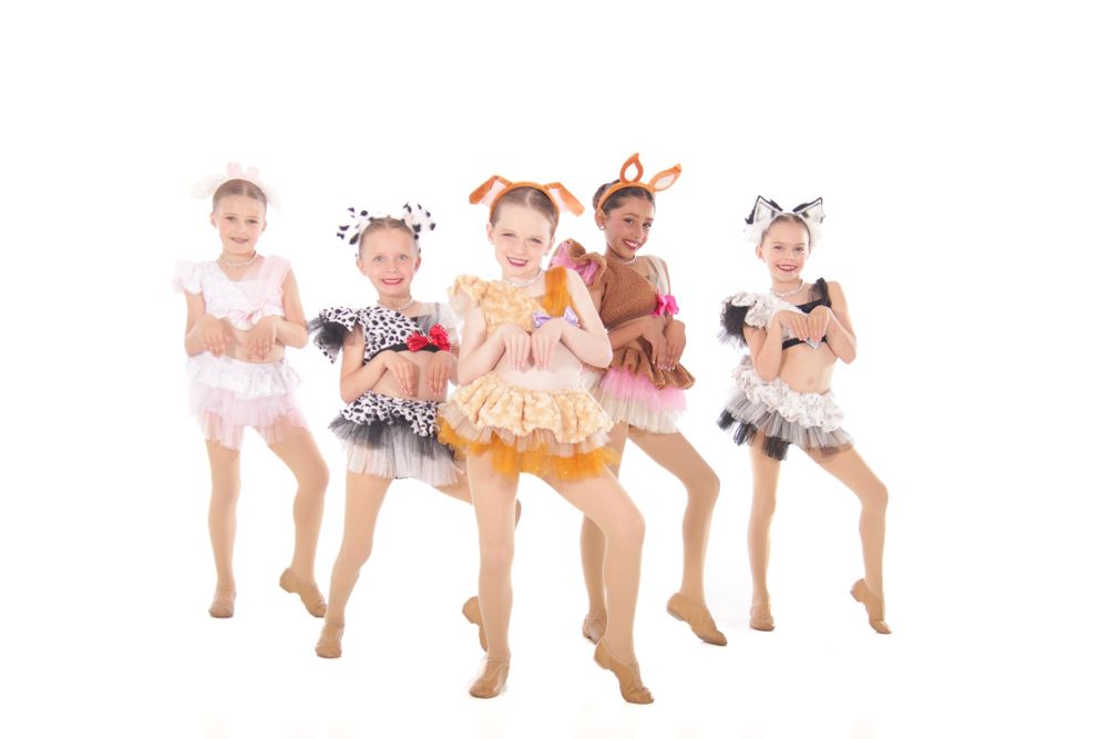 Dance ensemble performs synchronized routine in matching pastel-colored costumes.