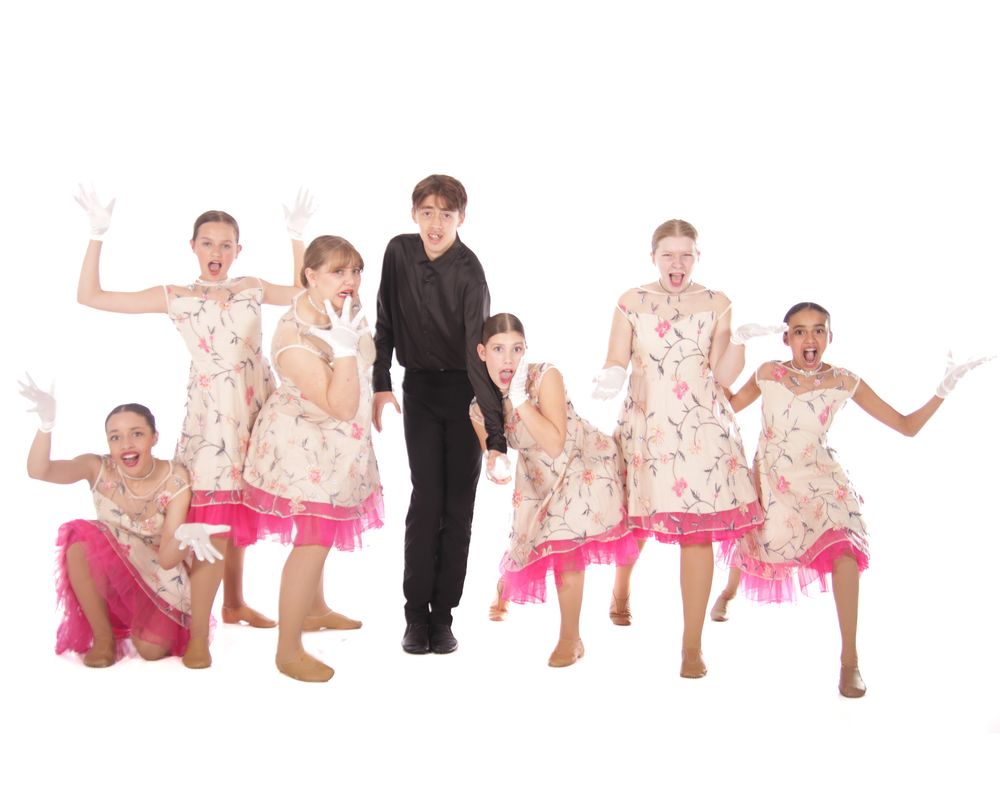 Dance ensemble wearing floral and pink costumes pose in sequence on white background.