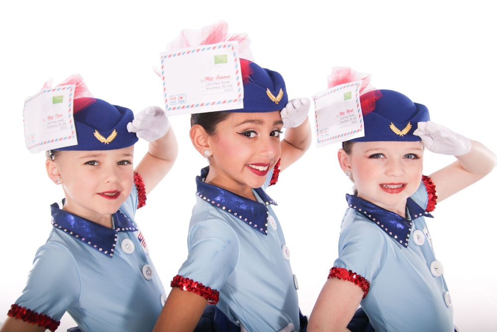 Dancers in matching blue and white baseball-inspired uniforms pose in sequence.