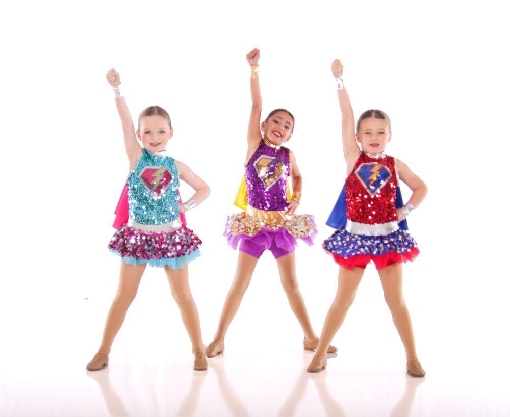 Young dancers in colorful sequined tutus perform splits and energetic dance moves.