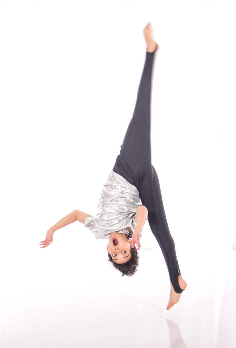 Contemporary dancer in black and silver performs dynamic sequence of movements.
