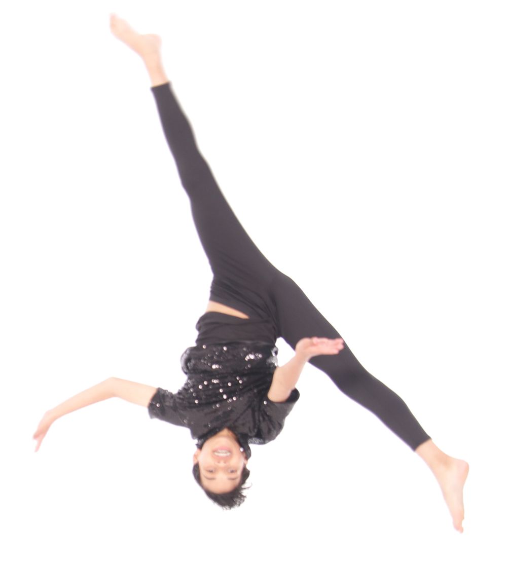 Performer in black costume executes dynamic aerial movements on white background.