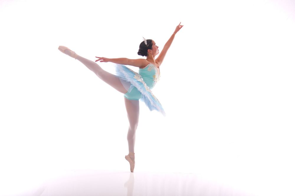 Graceful ballet dancers performing ethereal movements in soft lighting.