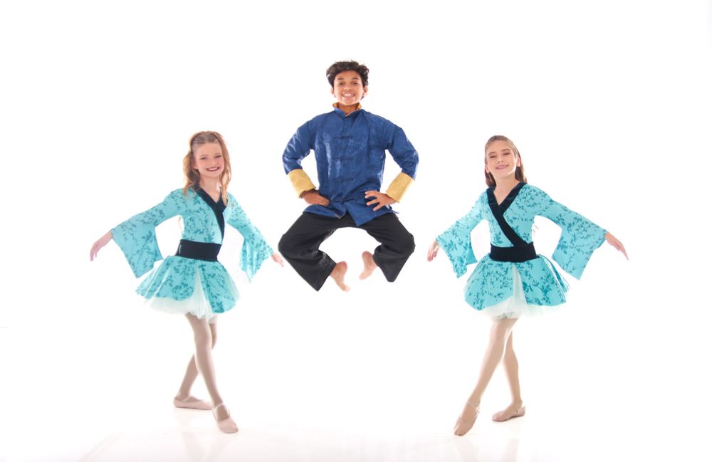 Dance ensemble in turquoise costumes performing synchronized choreography.