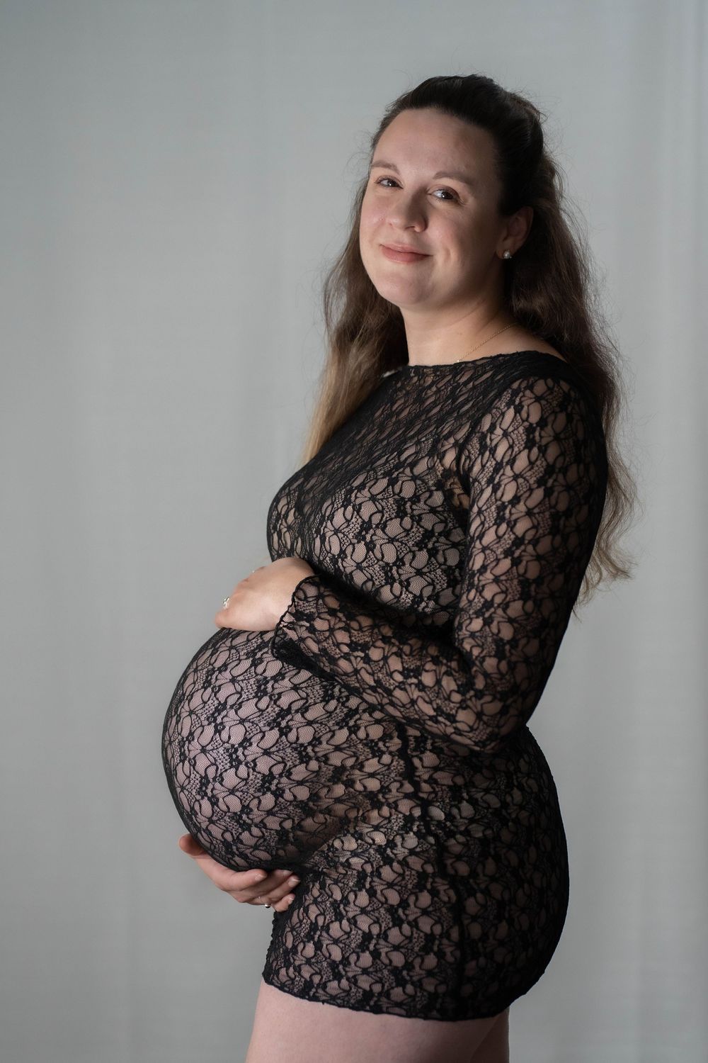 Artistic maternity portraits in black lace against a neutral background.
