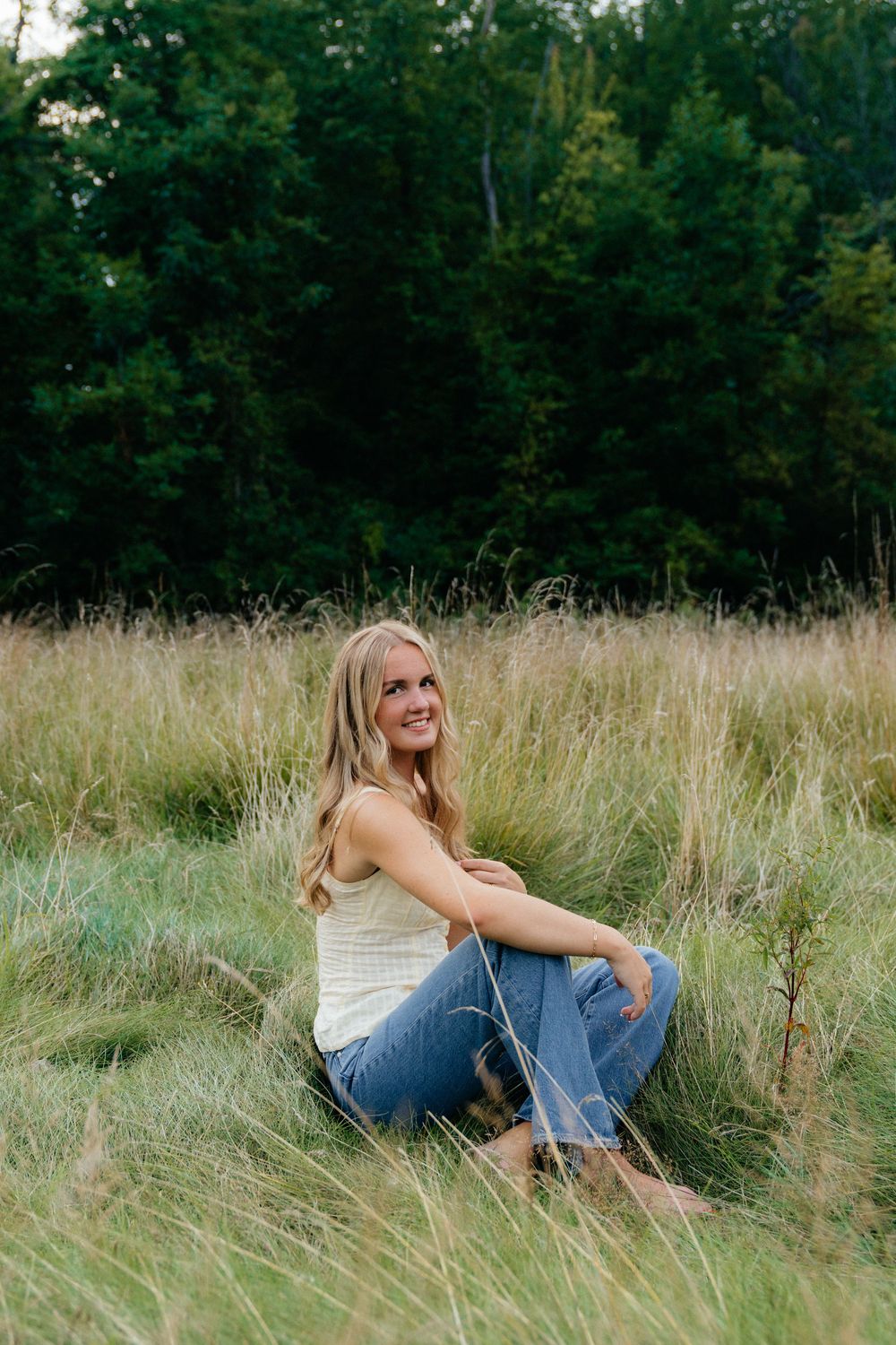 Relaxed outdoor portrait session in a wild grass meadow during golden hour.