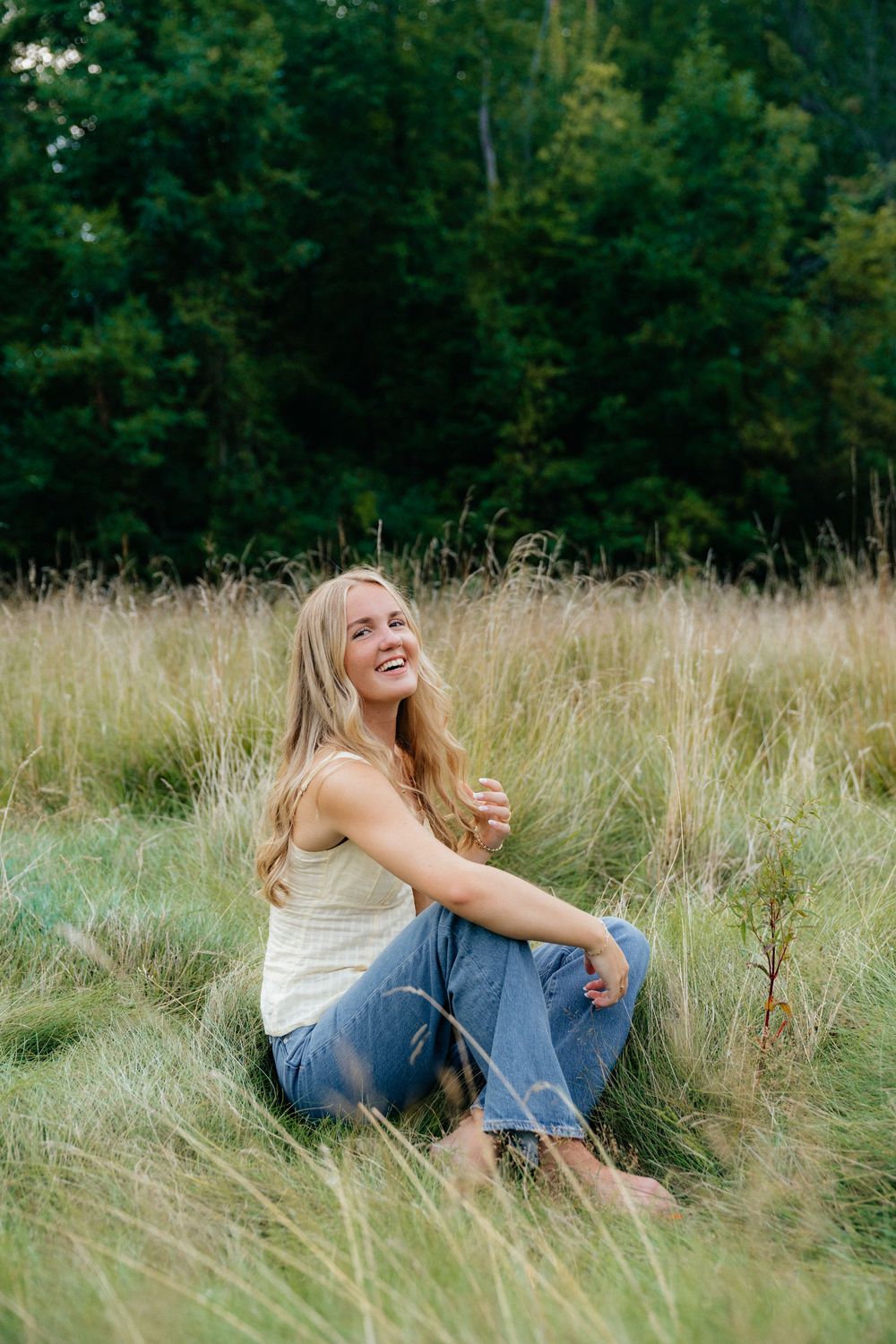 Joyful moments captured while sitting in tall meadow grass during sunset.