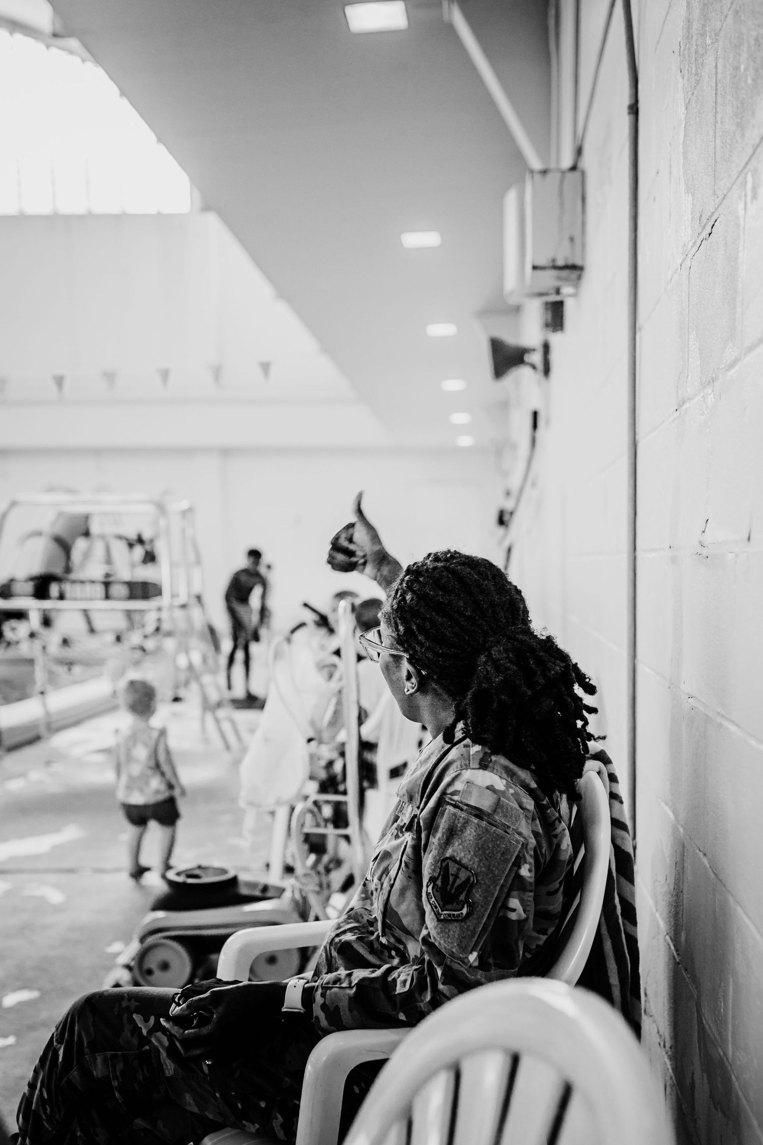 Mom in military uniform at public pool giving son a thumbs up. Whitney Popp photographer.