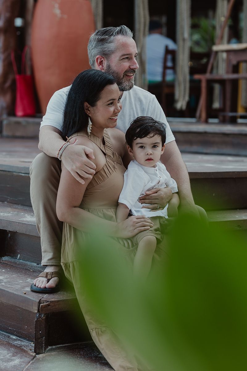 Parents sitting with child during luxury family photoshoot at La Zebra Hotel in Tulum, Riviera Maya.