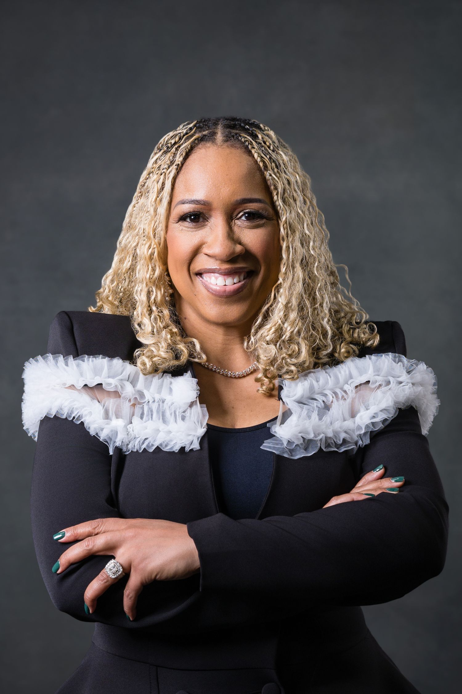 Professional portrait series showing a warm smile and white feathered collar against a dark background.