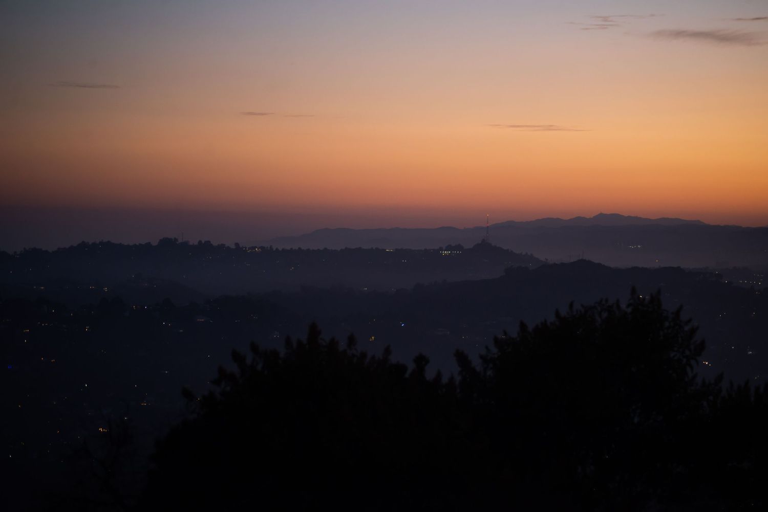 Beautiful sunset landscape view over dark mountain ridges with orange sky.