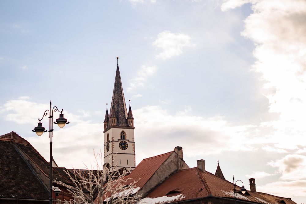 Historic church spires and red-roofed buildings line a traditional European town square.