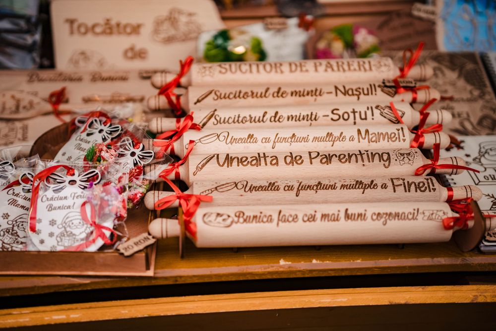 Traditional Romanian rolling pins with festive red ribbons displayed at a Christmas market stall.