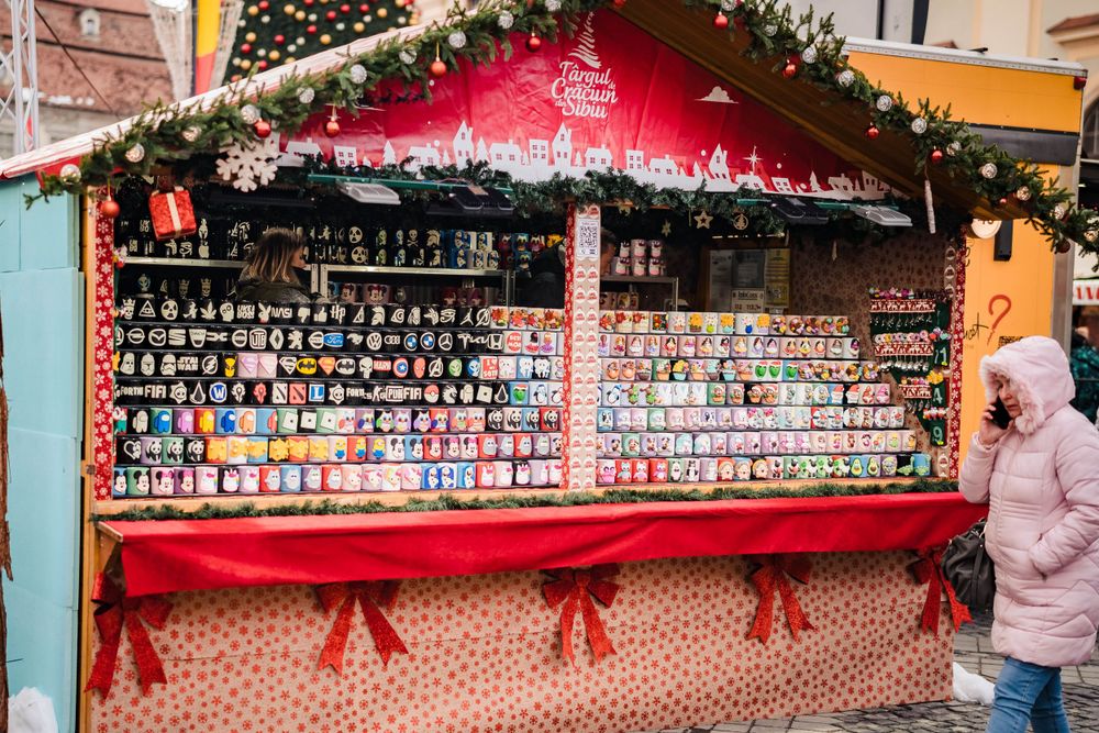 Festively decorated market stall displaying rows of colorful Christmas ornaments and decorations.