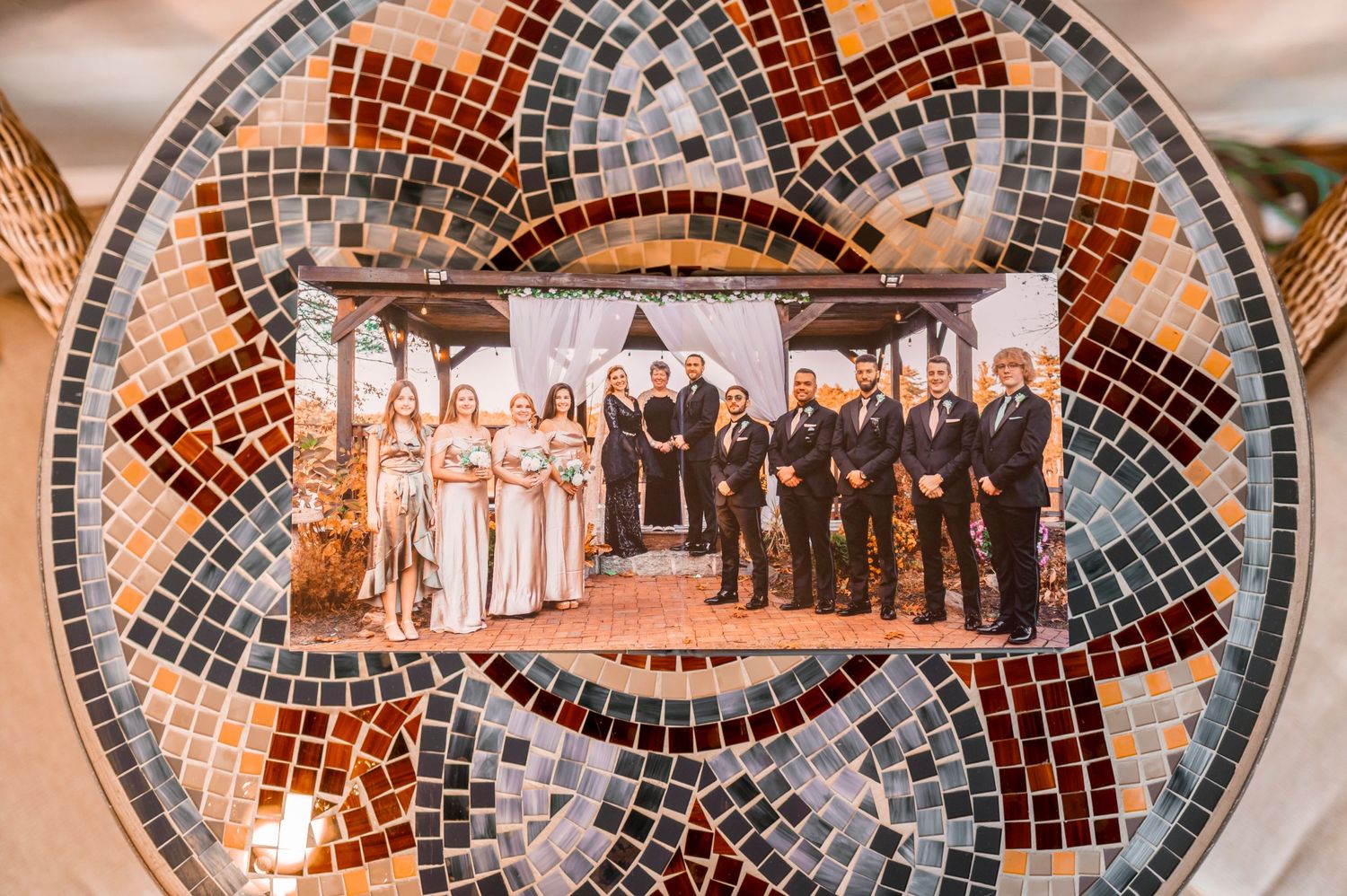 Wedding party photo displayed on ornate mosaic plate with orange and silver tiles.
