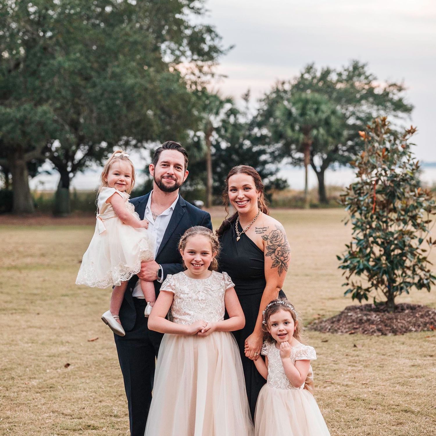 Family sitting together in a Christmas tree farm during a holiday photography session.