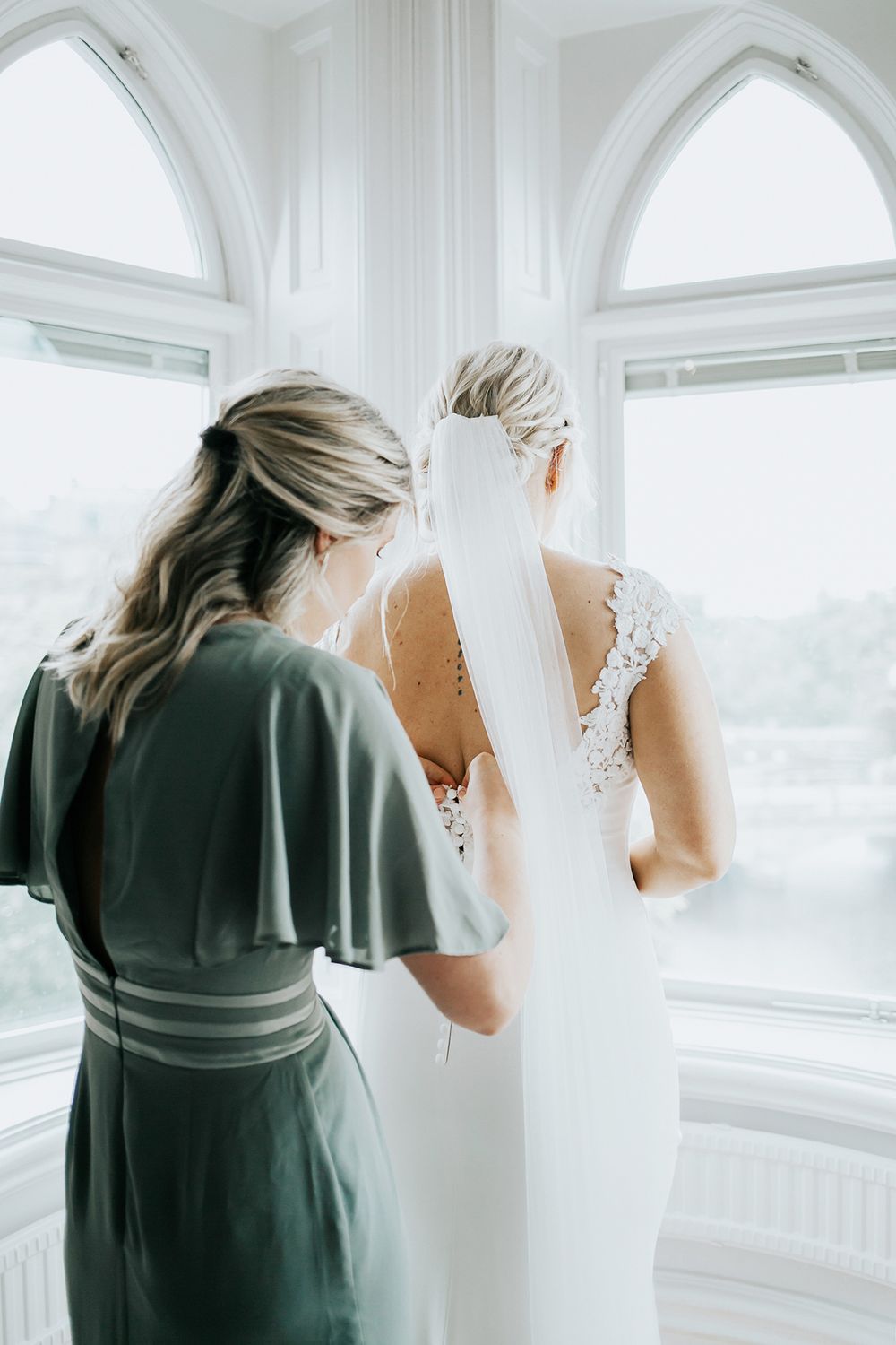 Bruden tar på sig sin klänning på Borgen hotell i Örebro. Bröllopsfotograf Rebecca Nordin.