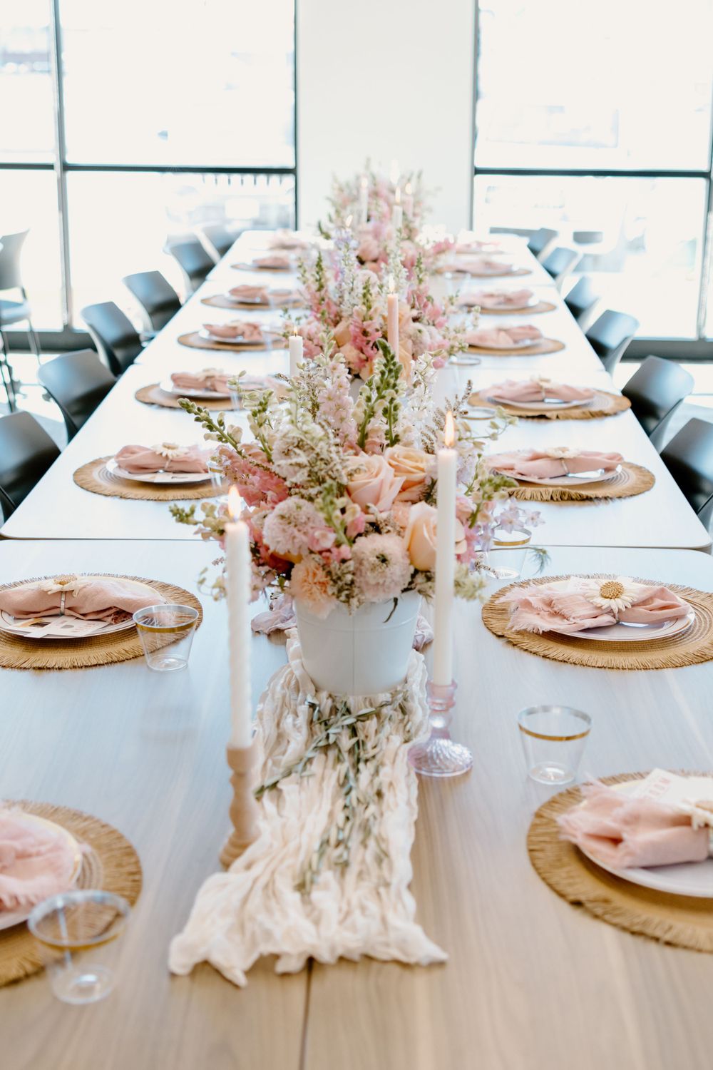 Elegant table setting with pink florals, gold chargers and white linens for a special celebration.