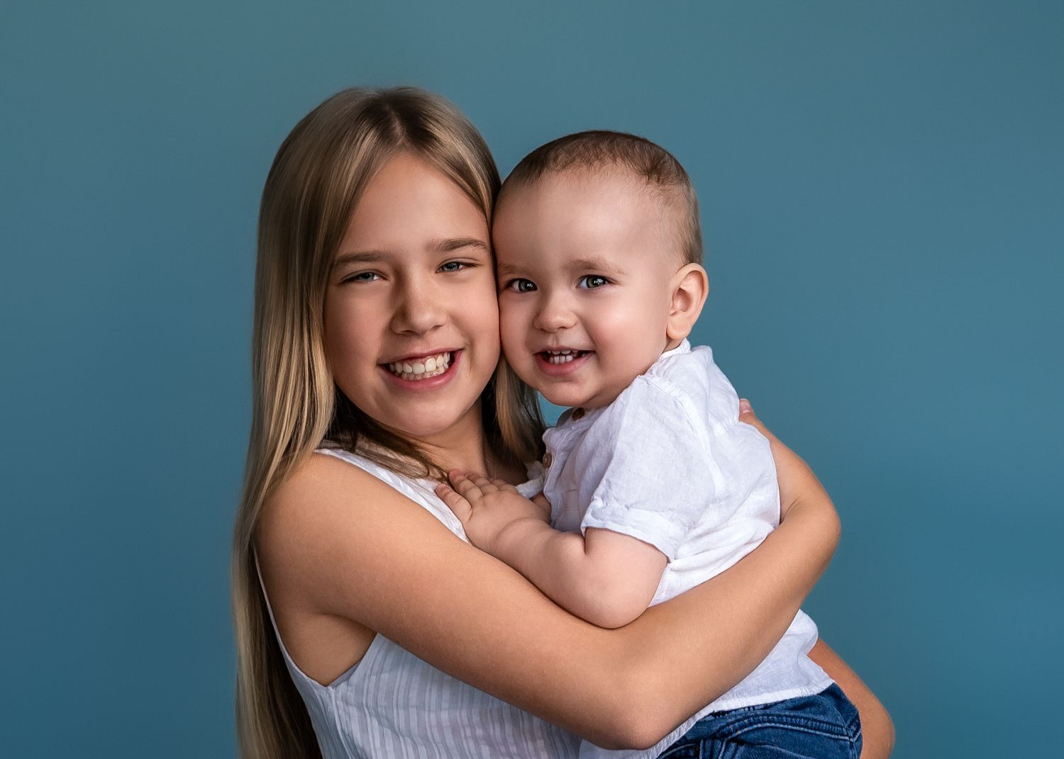 A joyful portrait moment against a blue studio backdrop.