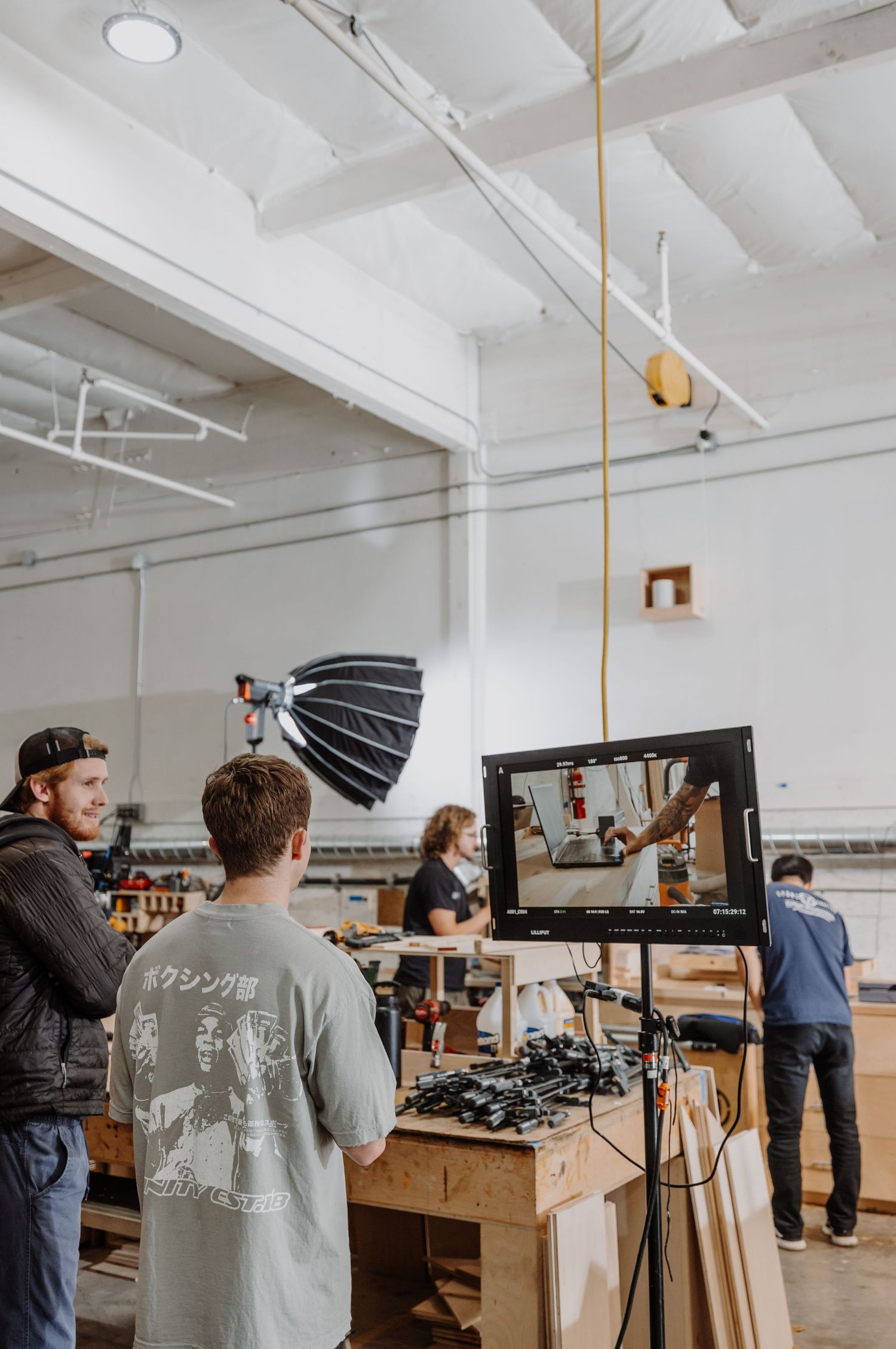 Photography studio setup with lighting equipment and people working in an industrial white space.