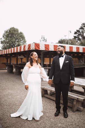 Wedding couple sharing a candid moment on a rustic wooden deck.