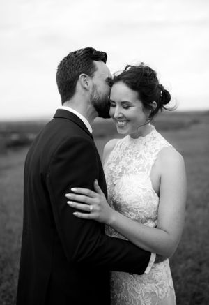 Black and white intimate portrait of newlyweds sharing a tender moment.