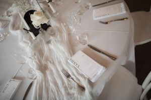 Wedding details and accessories arranged on white surface in soft focus.