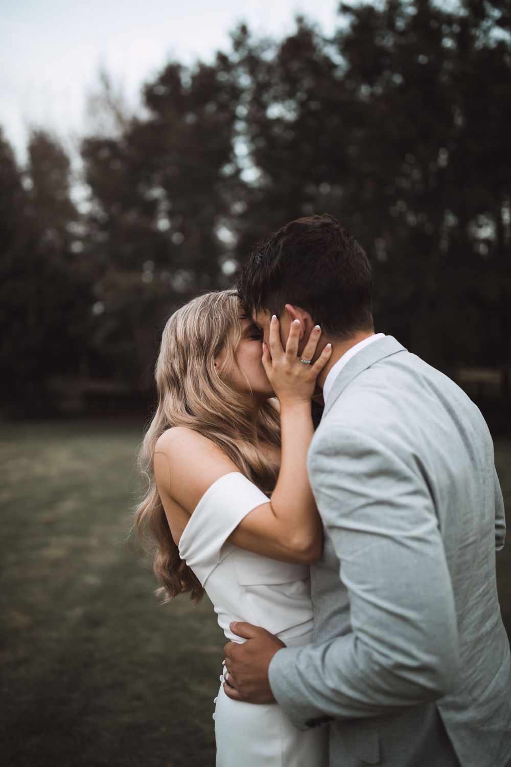 An intimate wedding moment captured during sunset in a forest setting.