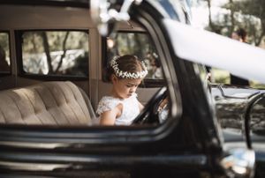 A vintage car interior with a delicate lace veil visible through the window.