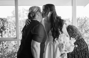 Wedding party silhouettes against bright window during indoor preparation.