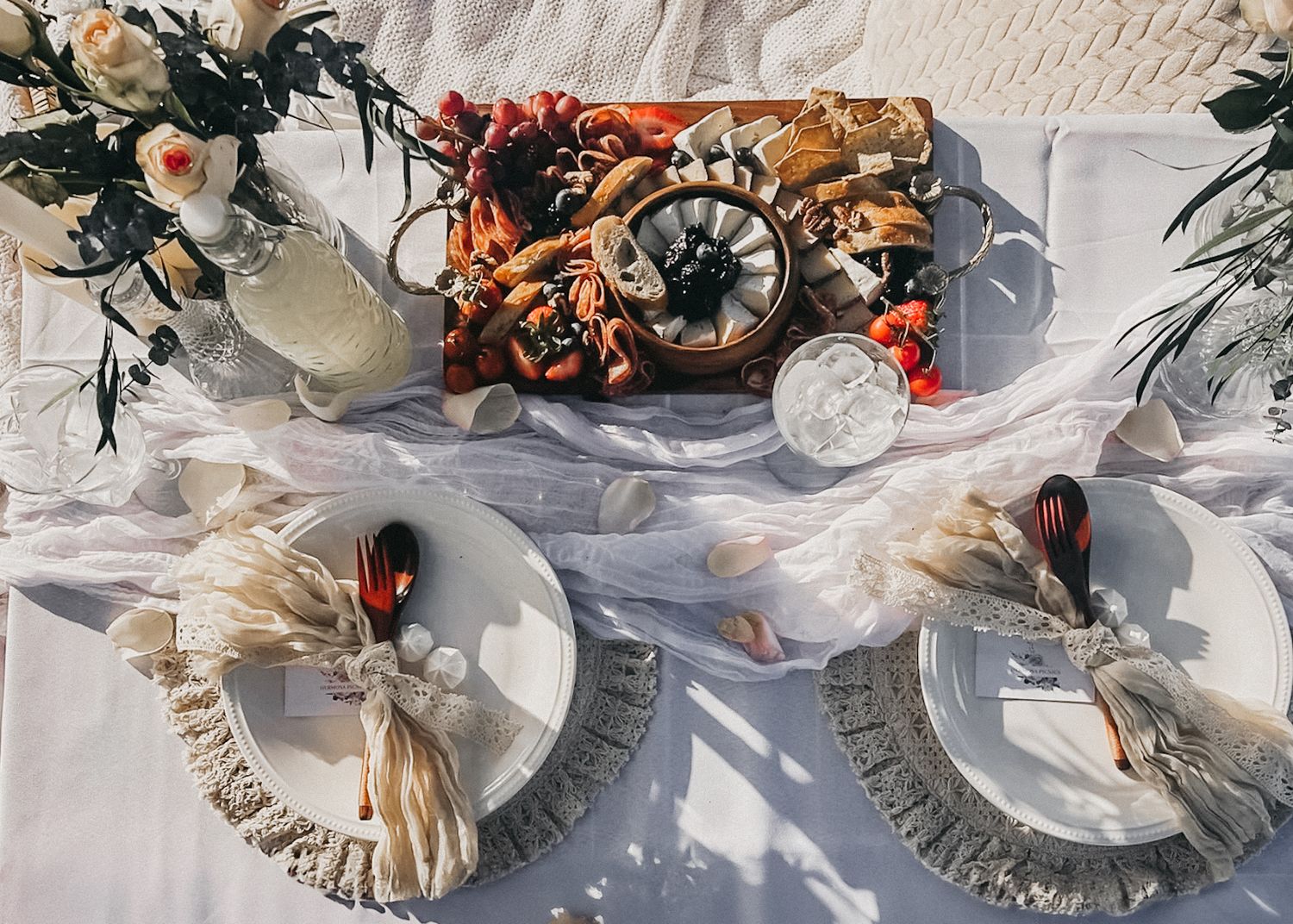 Elegant table setting with white plates, floral arrangements and rustic decor.