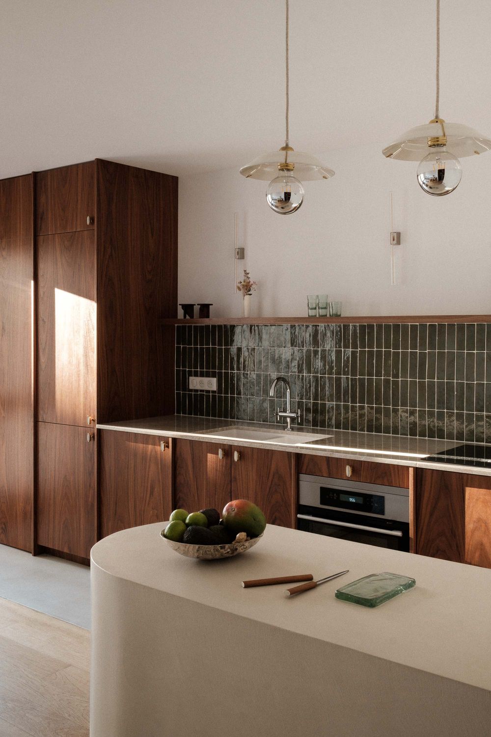Contemporary kitchen with dark wood cabinets, green tile backsplash, and pendant lighting.