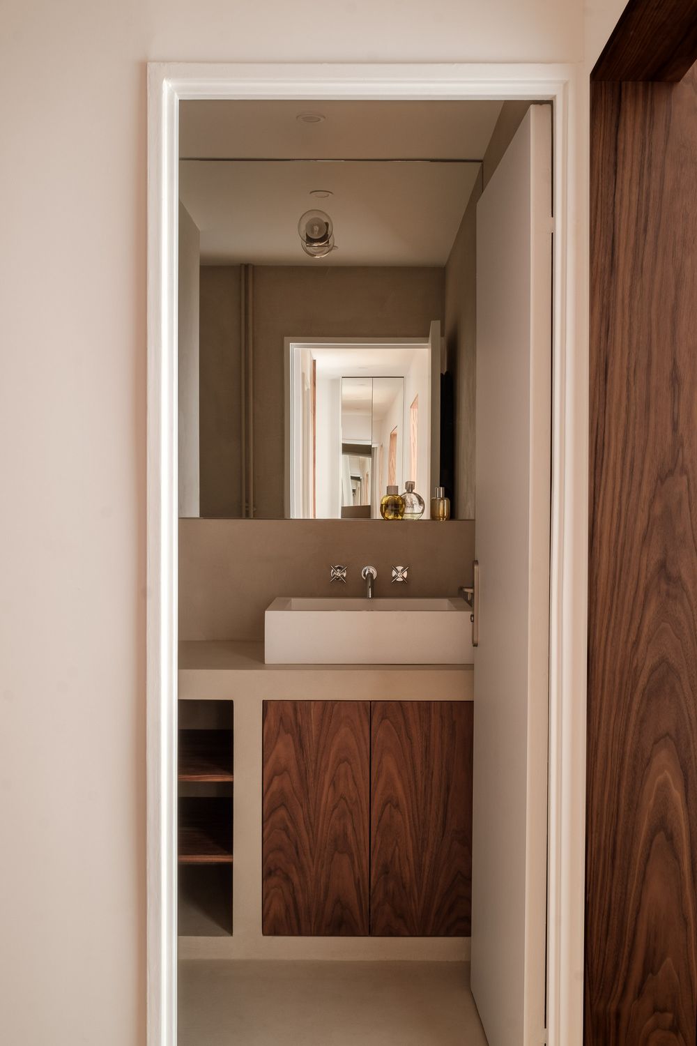Modern minimalist bathroom with wooden vanity, vessel sink, and clean lines in neutral tones.
