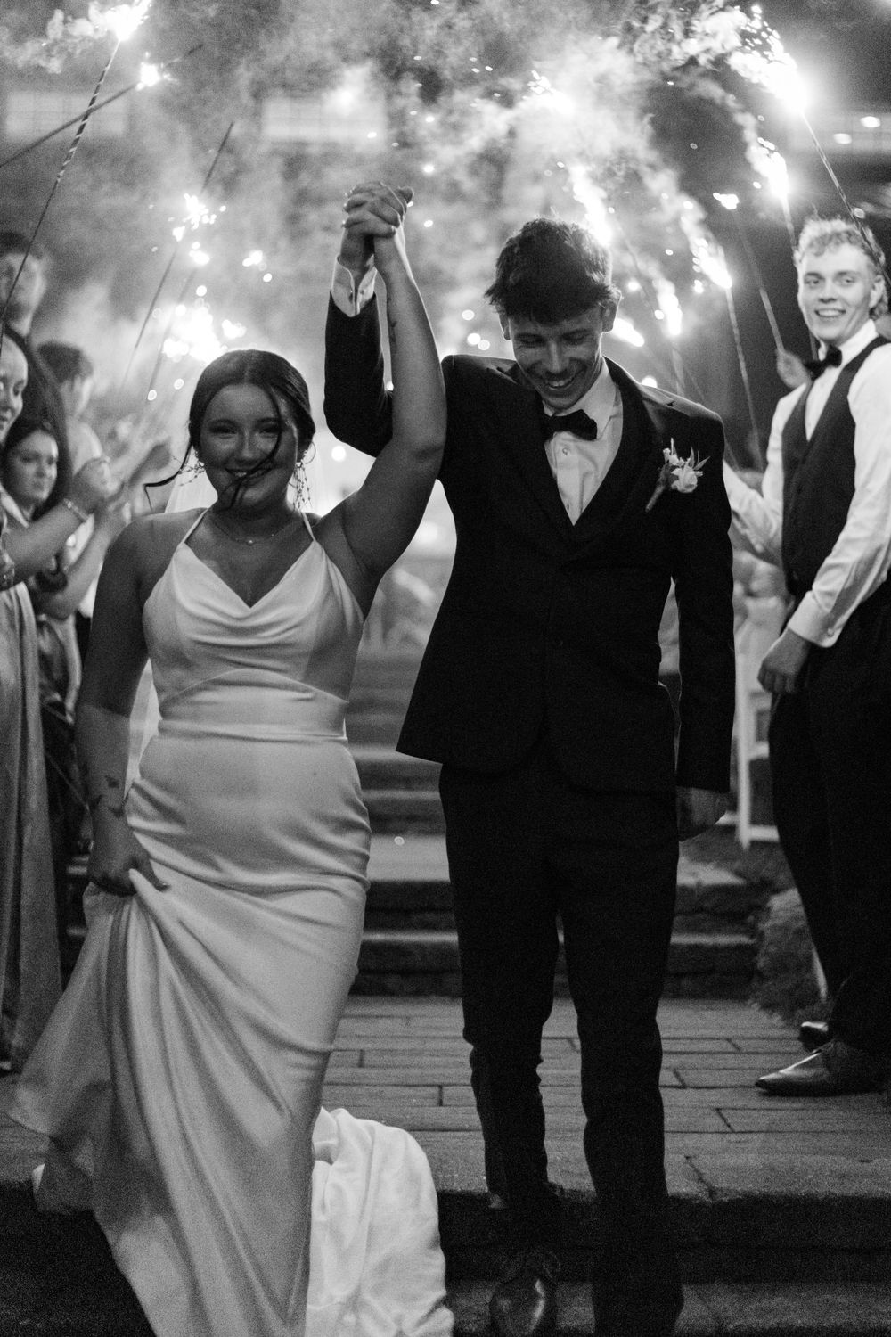 Wedding couple celebrates under sparkler arch during grand exit.