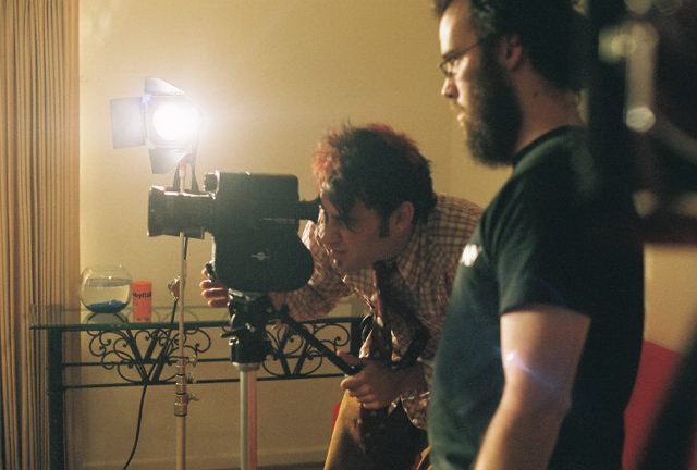 Film crew working with professional camera equipment in moody lighting during a production shoot.
