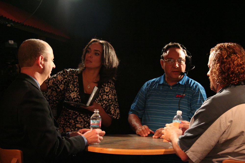 Group engaged in discussion around table during film production meeting.
