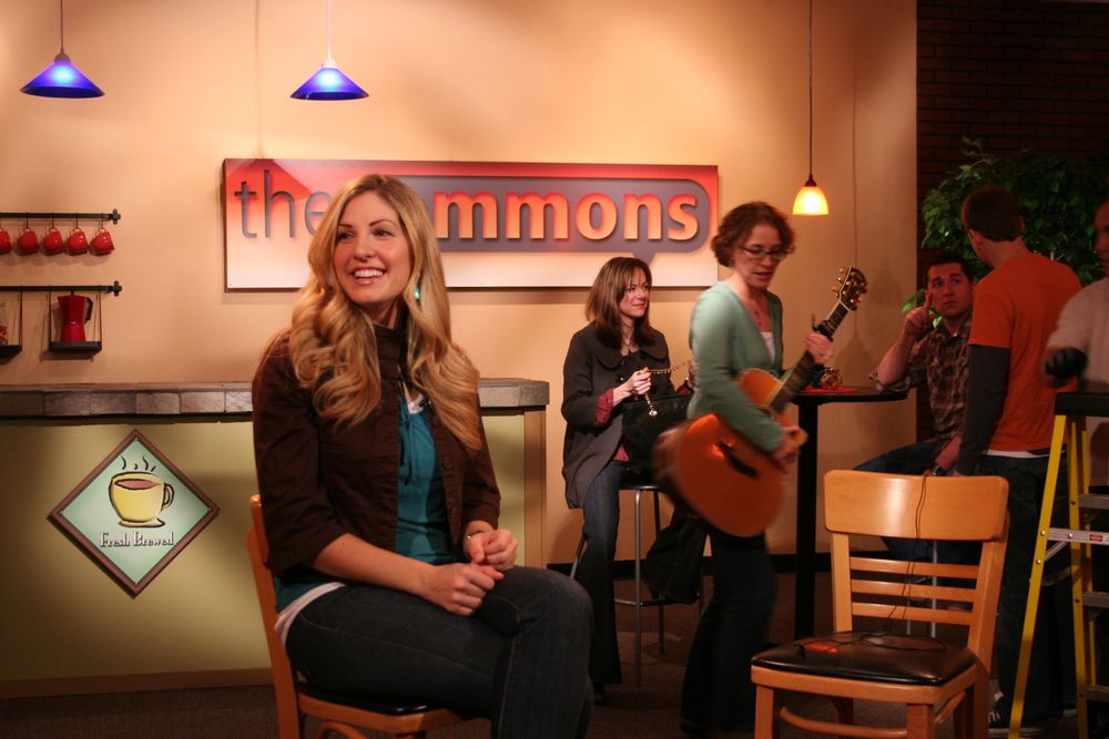 Musicians performing in a cafe-style venue with blue pendant lights.