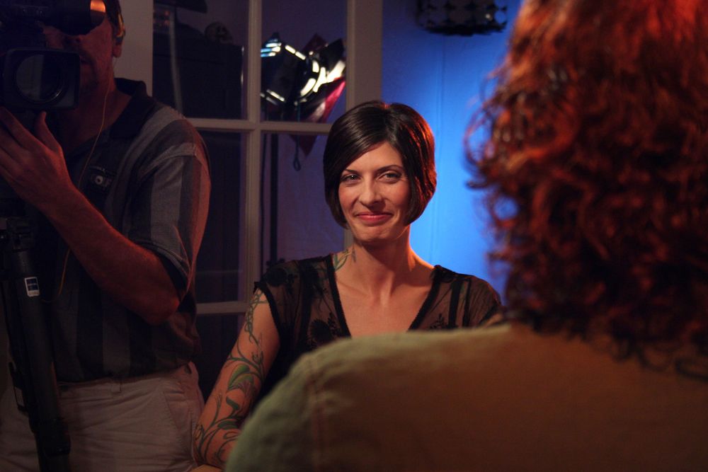 Film crew member illuminated by blue lighting during evening production shoot.
