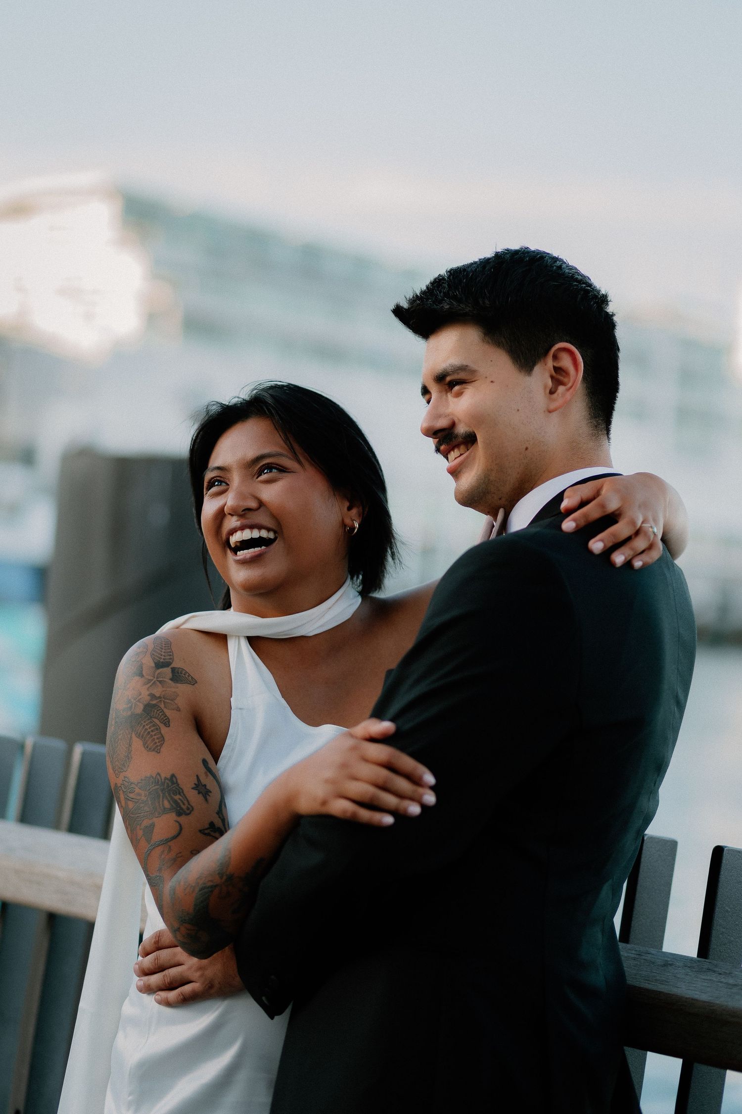 Urban couple sharing joyful moment with Auckland city CBD backdrop, New Zealand