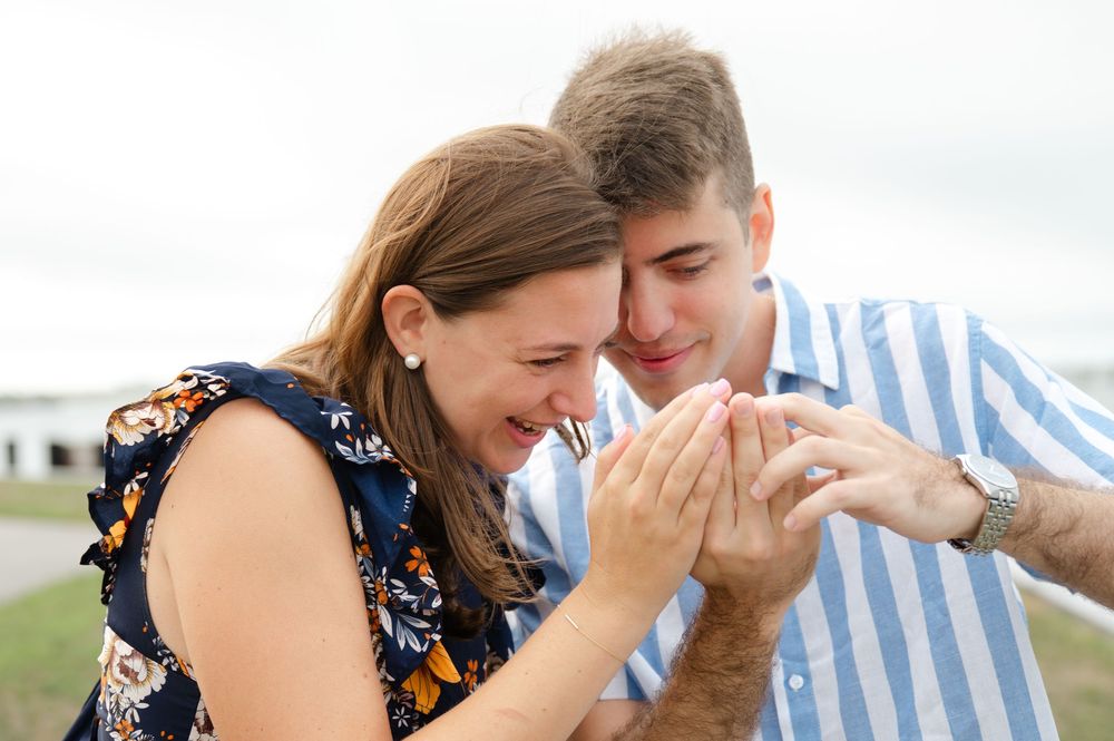 A couple shares a joyful moment together outdoors while sitting close and smiling.