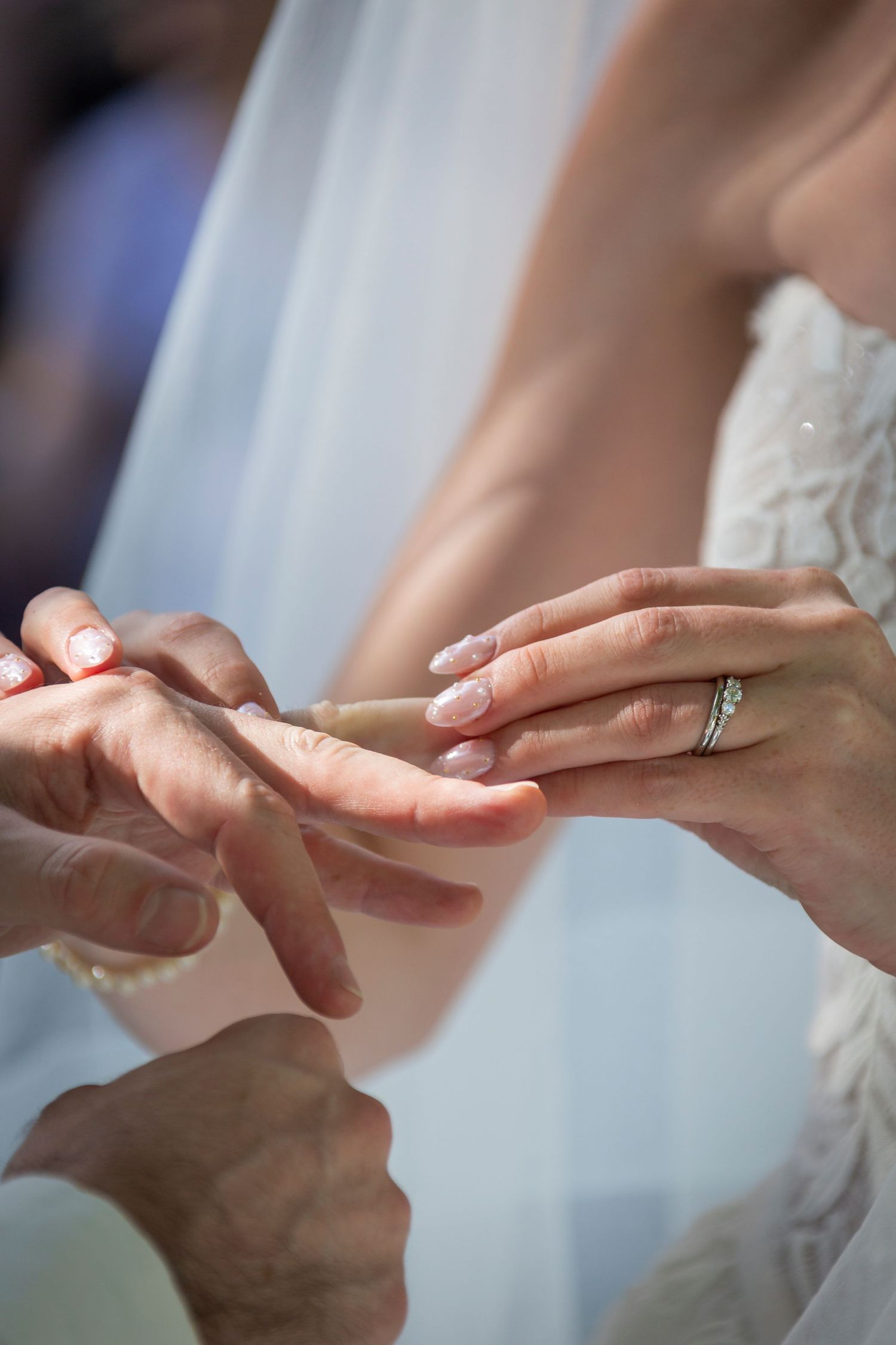 A close-up sequence showing a wedding ring being placed on a finger during a marriage ceremony.