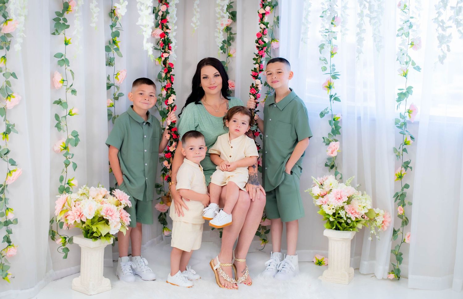 Floral themed photo session with decorative vine backdrop and white columns.