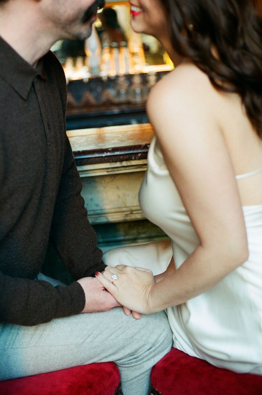 Close-up view of couple's hands holding each other tenderly in romantic moment.