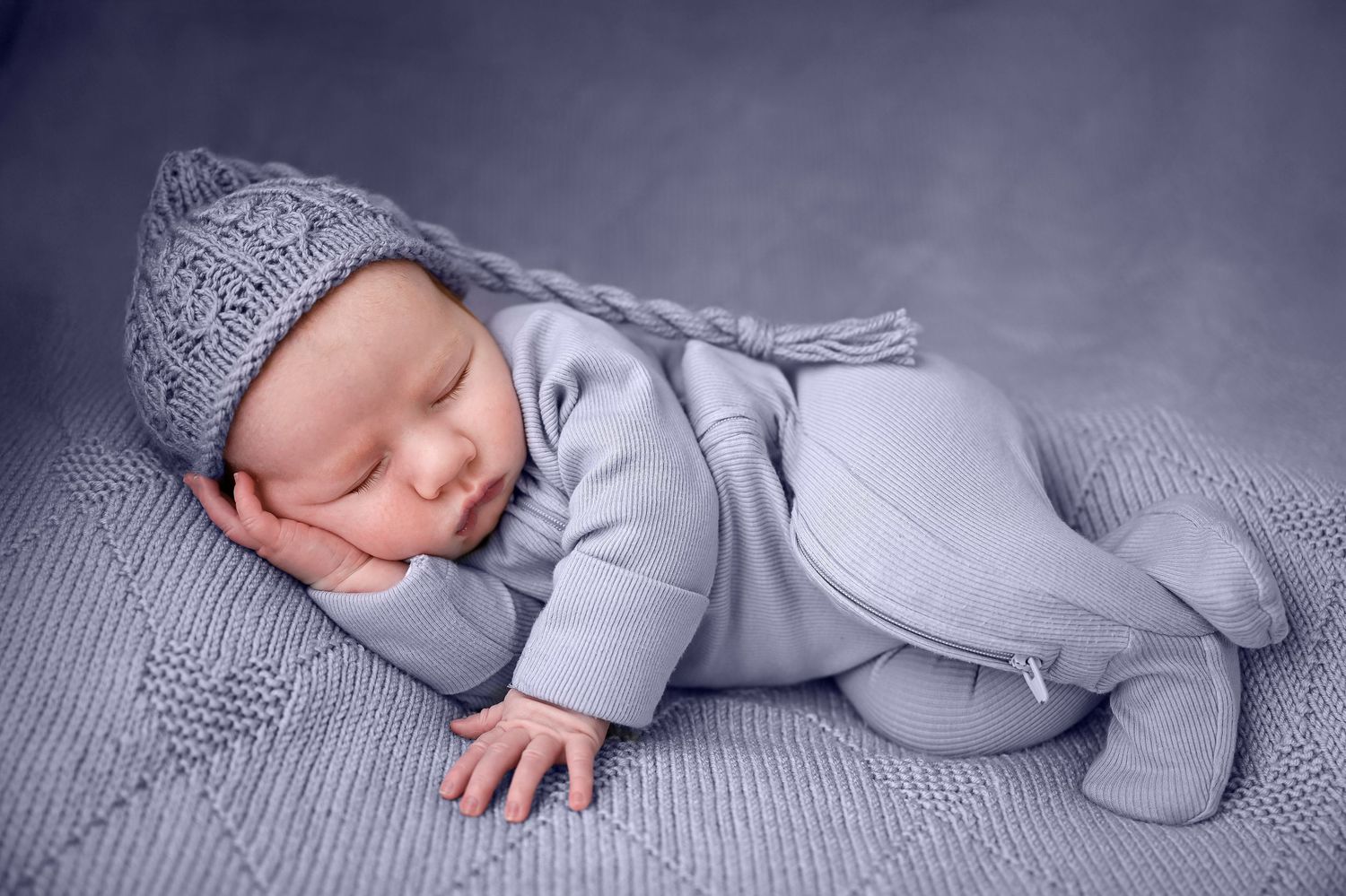newborn photography studio ashford kent photo of a baby in blue laying on one side  timeless photography creating memories