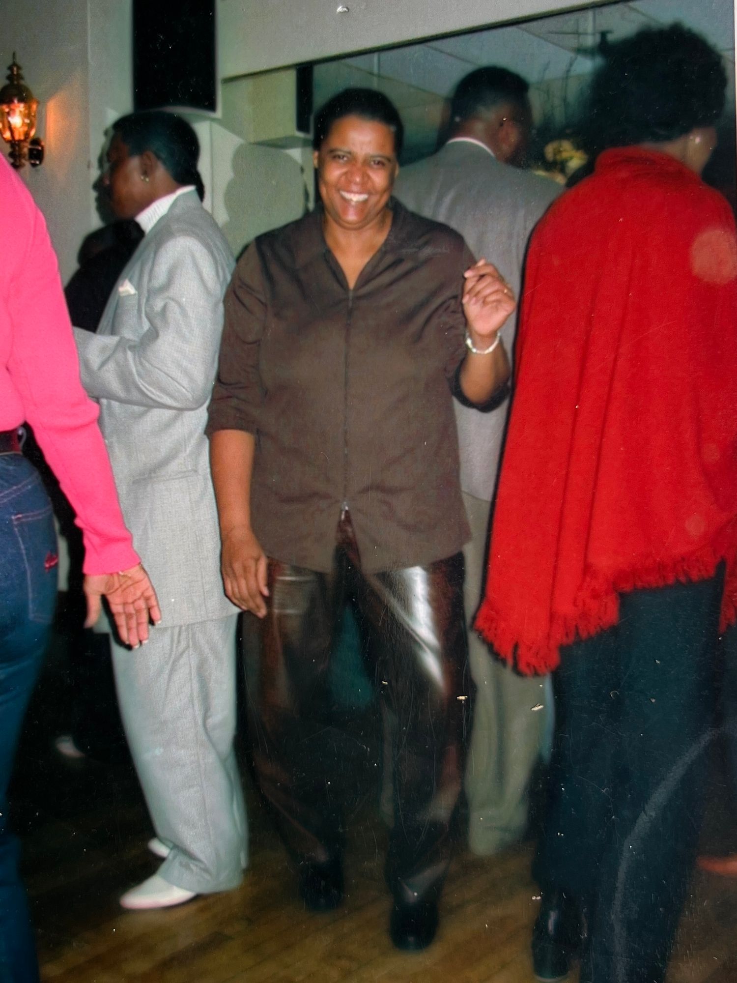 Group of people dancing and socializing at an indoor party.