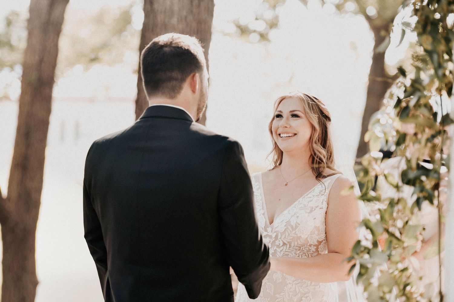 Bride and groom sharing emotional vows during their spring wedding ceremony beneath oak trees at Towering Oaks Wedding Venue.