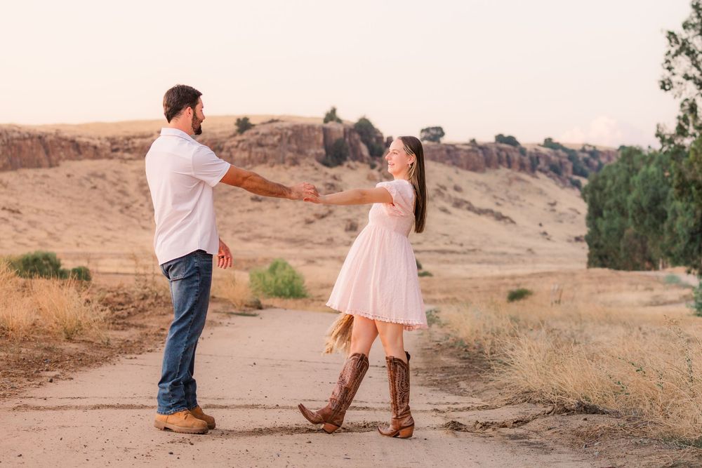 Couple in western boots walking together in a desert landscape during sunset.