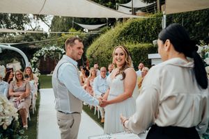 Wedding party dances together on an outdoor patio during a summer celebration.